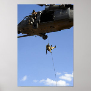 A pararescueman rappels from an HH-60 Poster