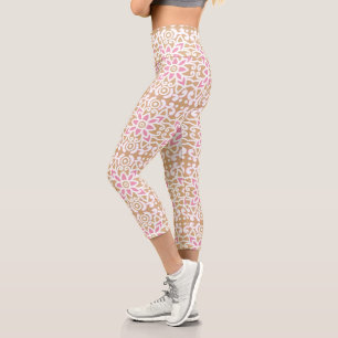 a pink and white flower pattern on a brown backgro capri leggings