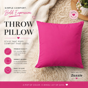 a pink background with a black cushion