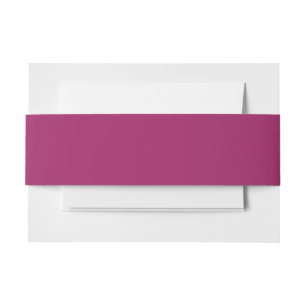 a pink background with a white invitation belly band