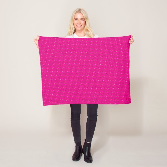 a pink background with white polka dots fleece blanket (In Situ)