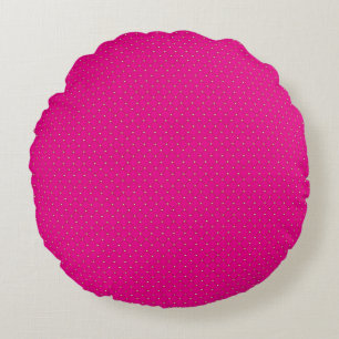 a pink background with white polka dots round cushion