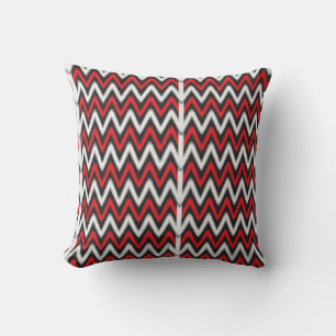 a red and black zigzag pattern on a white backgrou cushion