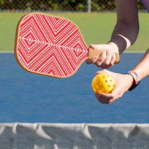 a red and white background with a diamond pattern pickleball paddle