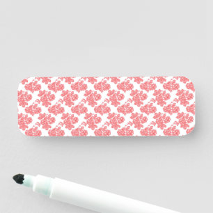 a red and white flower pattern on a white backgrou name tag