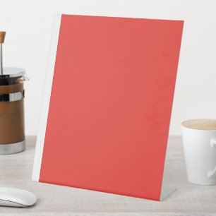 a red background with a white border pedestal sign