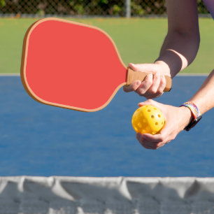 a red background with a white border pickleball paddle