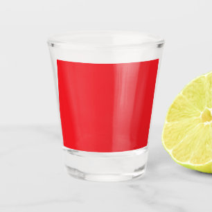 a red background with a white border shot glass