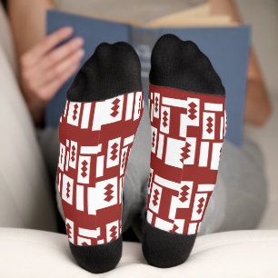 A red rug with a textured pattern is spread out on socks