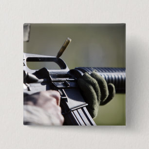 A round flies from the chamber of an M-16A2 15 Cm Square Badge