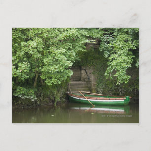 A Row Boat Roped At Some Stairs Along The Shore Postcard