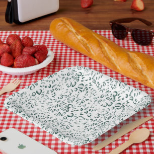 A silver drop splashes into a pool of white liquid paper plate