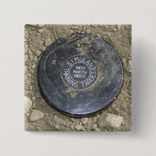 A simulated land mine 15 cm square badge