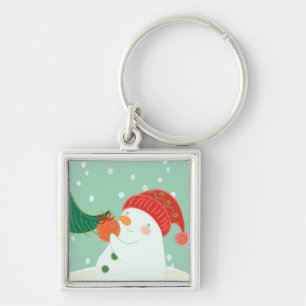 A snowman hanging an ornament on a tree key ring