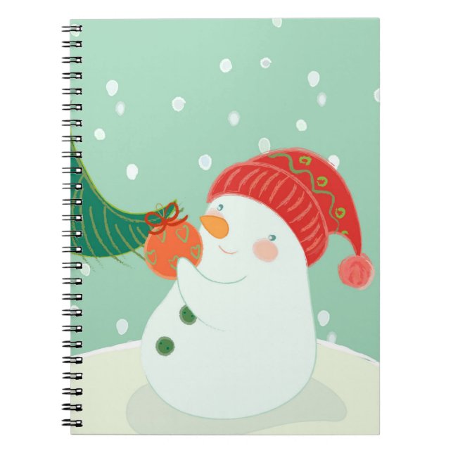 A snowman hanging an ornament on a tree spiral notebook (Front)
