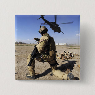 A soldier conducts security for an HH-60 15 Cm Square Badge