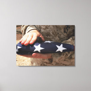 A soldier holds the United States flag Canvas Print