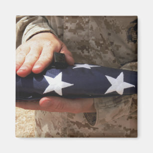 A soldier holds the United States flag Magnet