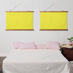 A vibrant yellow square enclosed by a crisp white  hanging tapestry