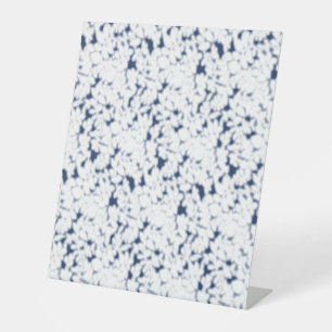 a white and blue background with a pattern pedestal sign