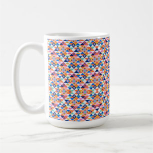 A white mug features a vibrant geometric pattern