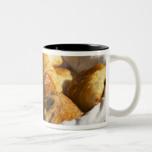 A wicker breakfast basket with croissants, and Two-Tone coffee mug