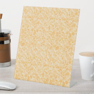 a yellow and white background with small white dot pedestal sign