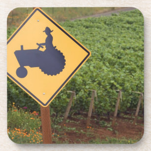 A yellow tractor crossing sign in the vineyard coaster