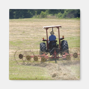 A young boy driving a tractor harvesting magnet