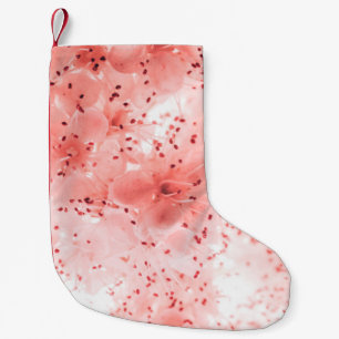 Abstract floral backdrop of pink flowers over past small christmas stocking