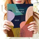 Abstract Shapes Geometric Lines Custom Name Planner<br><div class="desc">This bold and modern design features a vibrant abstract composition of organic shapes in deep navy, mustard, blush, and olive tones. Fine gold linework adds a touch of sophistication, while the personalised name and year create a unique and stylish finish. Perfect for artists, students, or professionals who love trendy and...</div>