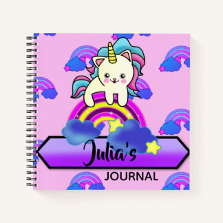 Adorable Unicorn Kitty Cat sitting on a Rainbow Notebook