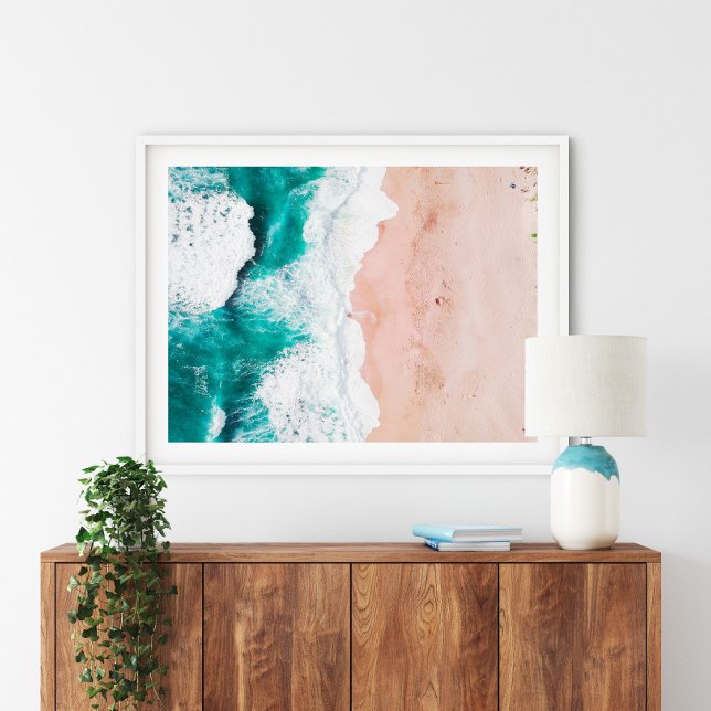 Aerial Ocean Waves and Pink Sand Beach Coastal Art Poster (Aerial Beach Poster Print in a white frame above a wooden small furniture.)