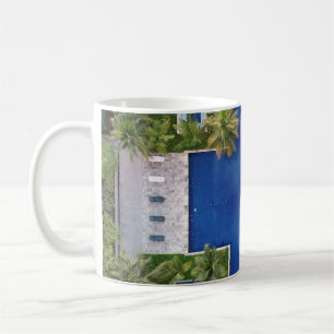 Aerial view of pool surrounded by palm trees coffee mug
