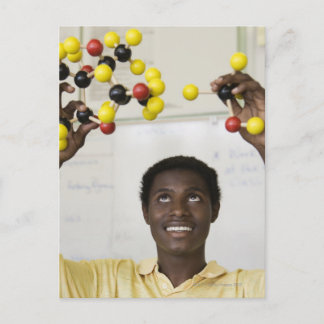 African teenage boy viewing molecule model postcard