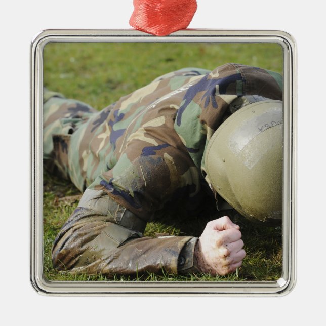 Airman crawls through a wet field metal tree decoration (Front)