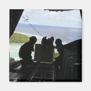Airmen push out a pallet of donated goods magnet