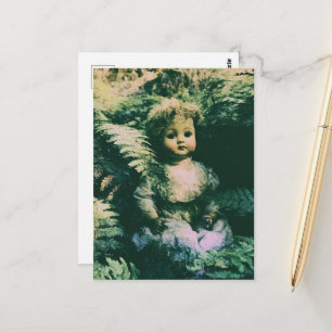 An abandoned cute spooky doll in the forest postcard