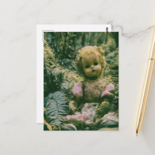 An abandoned doll in the forest postcard