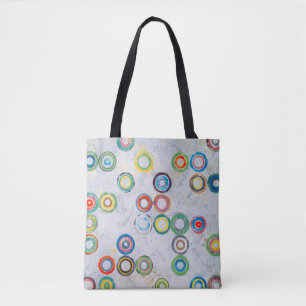 An abstract painting; multicolored circles on a gr tote bag