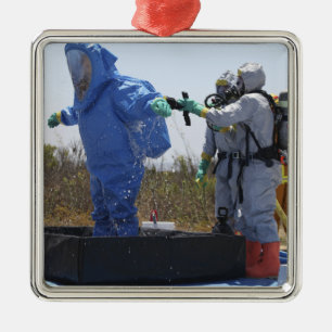 An airman stands in a tub metal tree decoration