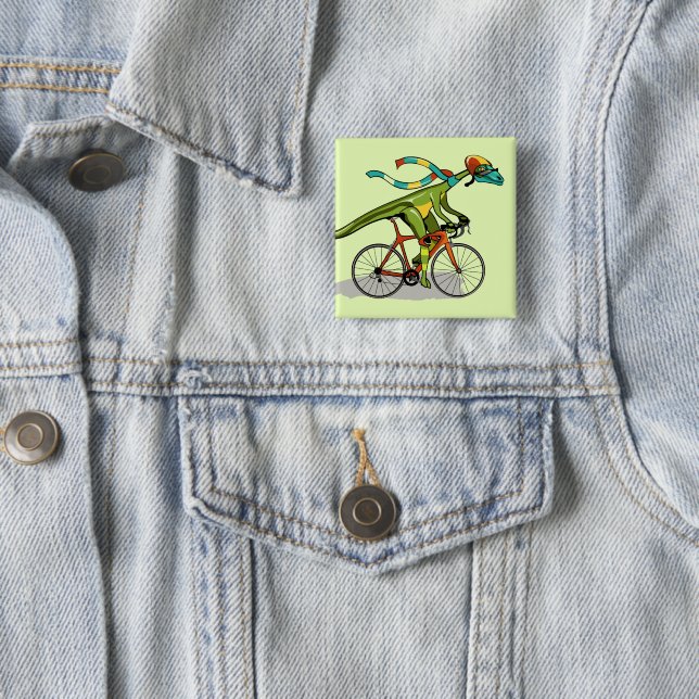 An Anabisetia Dinosaur Riding A Bicycle. 15 Cm Square Badge (In Situ)