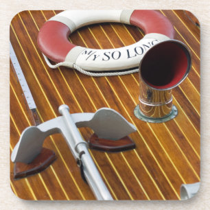 An Anchor And A Life-Buoy On A Wooden Boat Coaster