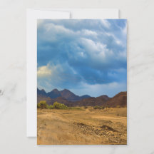 An arid landscape under a dramatic, cloudy sky
