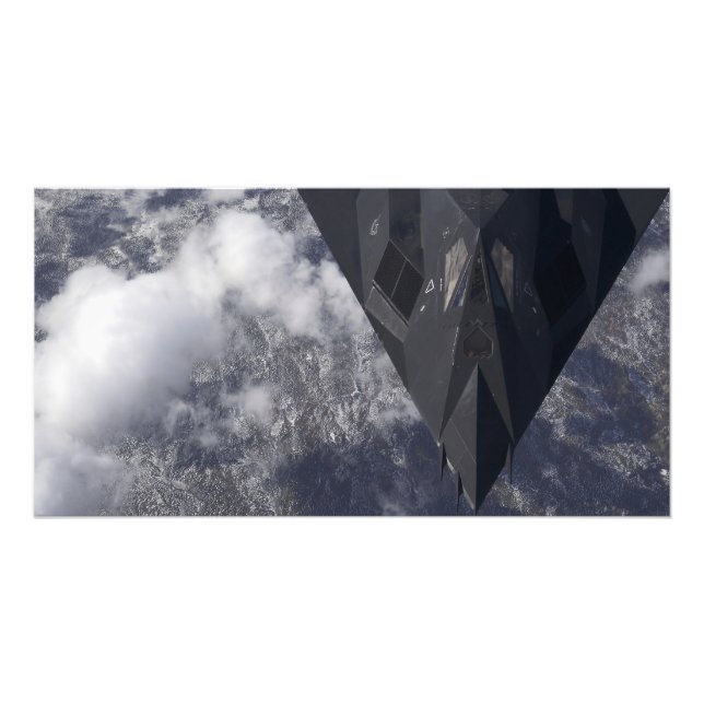 An F-117A Nighthawk flies high over the mountai Photo Print (Front)