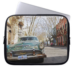 An old car rusty and flaky colour parked in the laptop sleeve