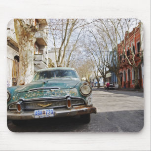 An old car rusty and flaky colour parked in the mouse pad