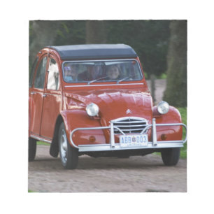 An old red Citroen 2CV car with a smiling woman Notepad