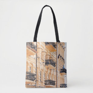 An old yellow house with wrought-iron balconies. f tote bag