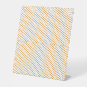 an orange and white background with small circles pedestal sign